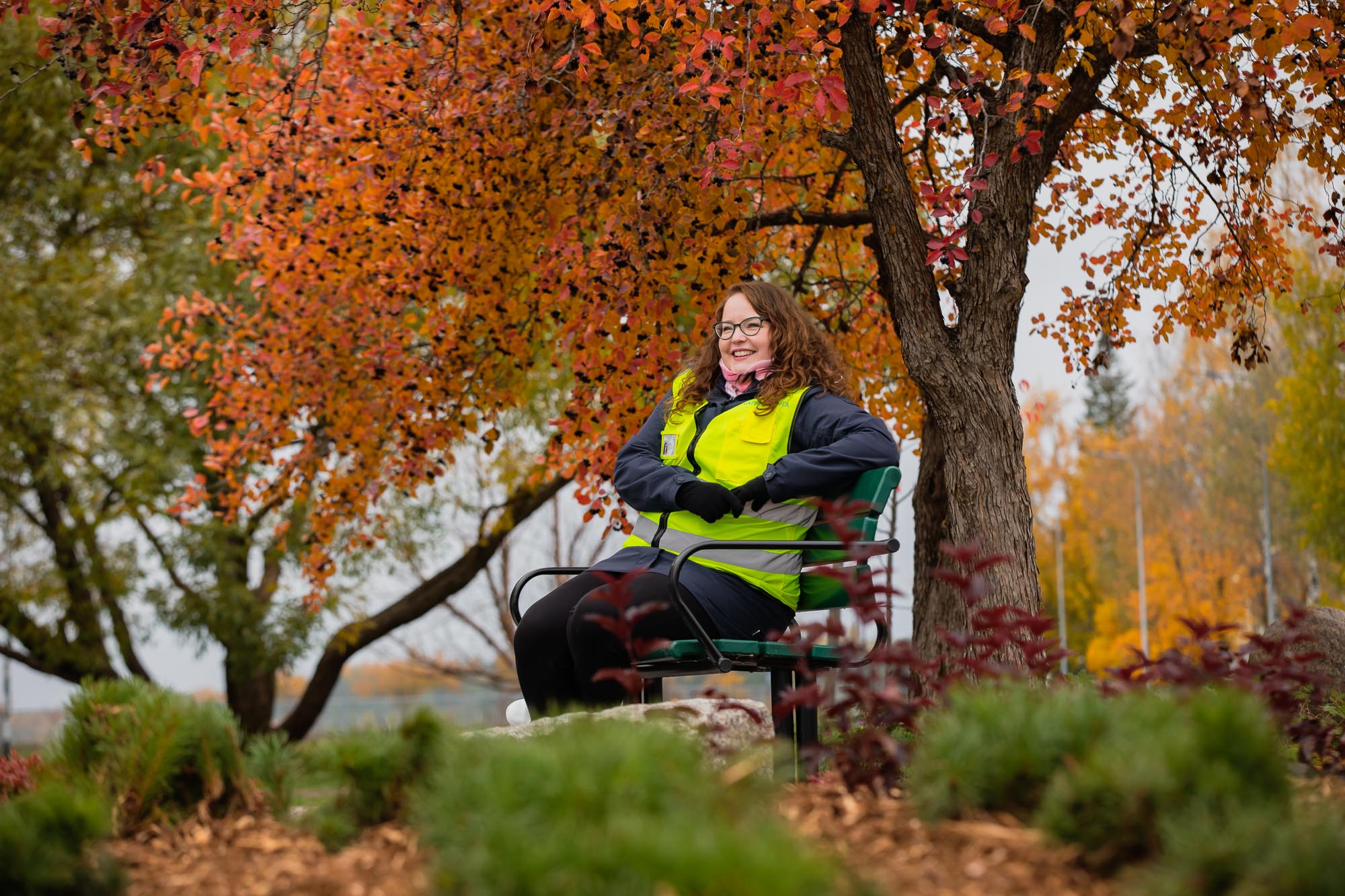 Kaupunginpuutarhuri Laura Ratilainen istuu puistonpenkillä.